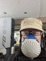 Der Maschinen-Bediener mit Staubschutz-Vermummung